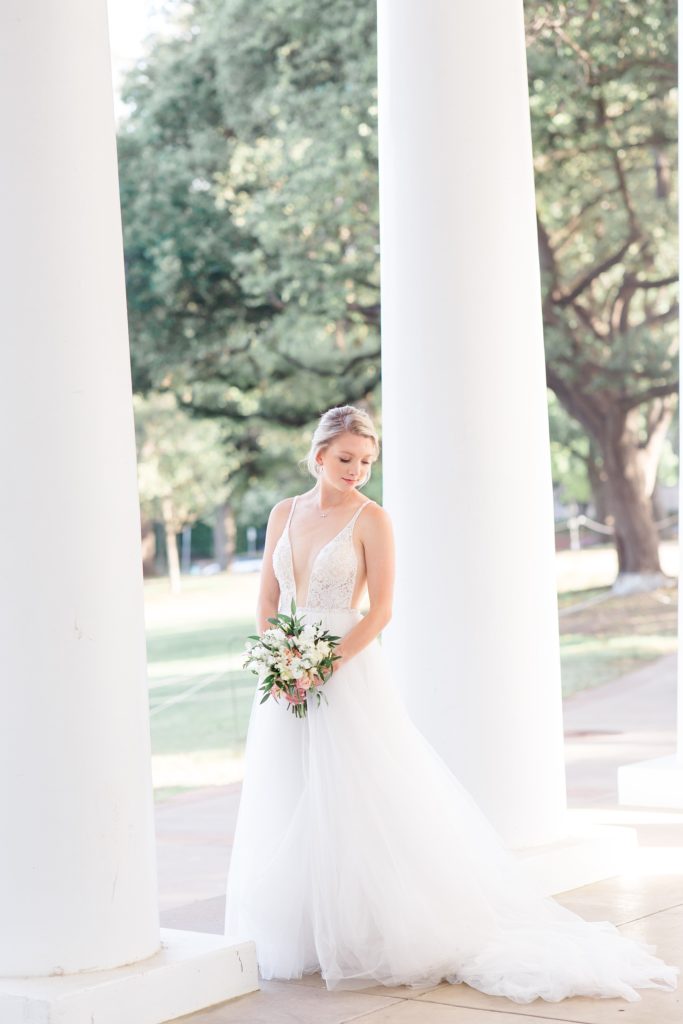 bride poses by columns at Arlington Hall photographed by Courtney Bosworth Photography