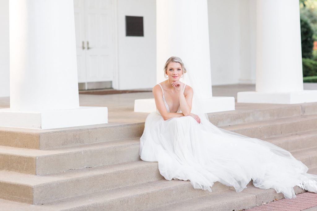 bride sits on steps at Arlington Hall at Lee Park photographed by Courtney Bosworth Photography