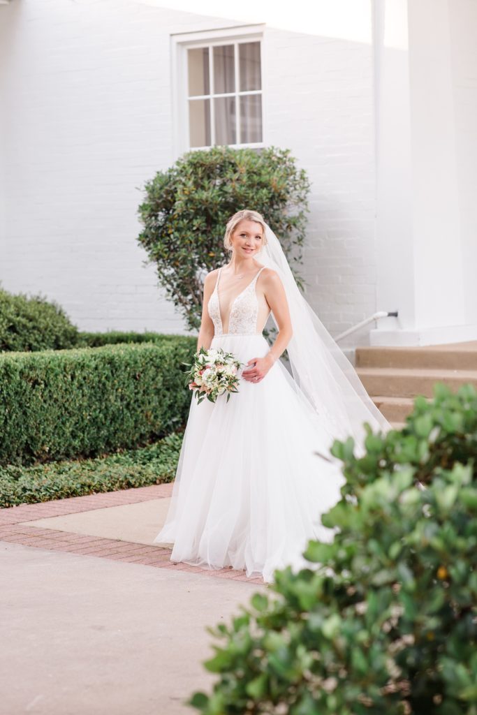 bride holds bouquet and smiles at Courtney Bosworth Photography