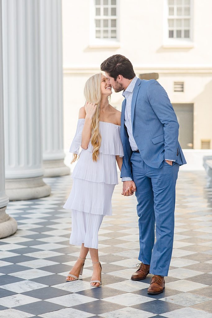 bride leans up to groom to kiss him during SC engagement photos