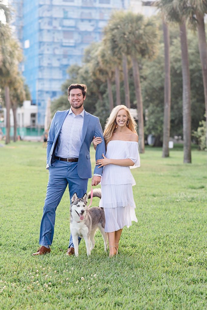 bride and groom walk through park with dog in Charleston SC