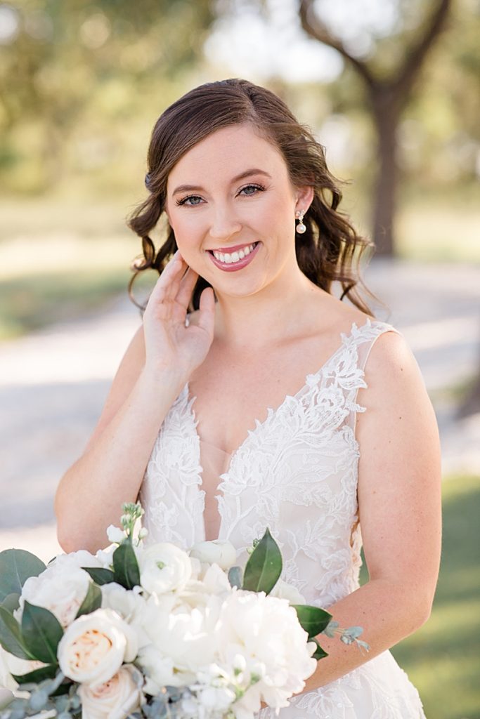 Texas bride in lace gown poses during Mae's Ridge bridal portraits 