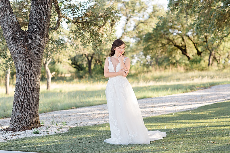 bride stands in grass photographed by TX wedding photographer Courtney Bosworth Photography