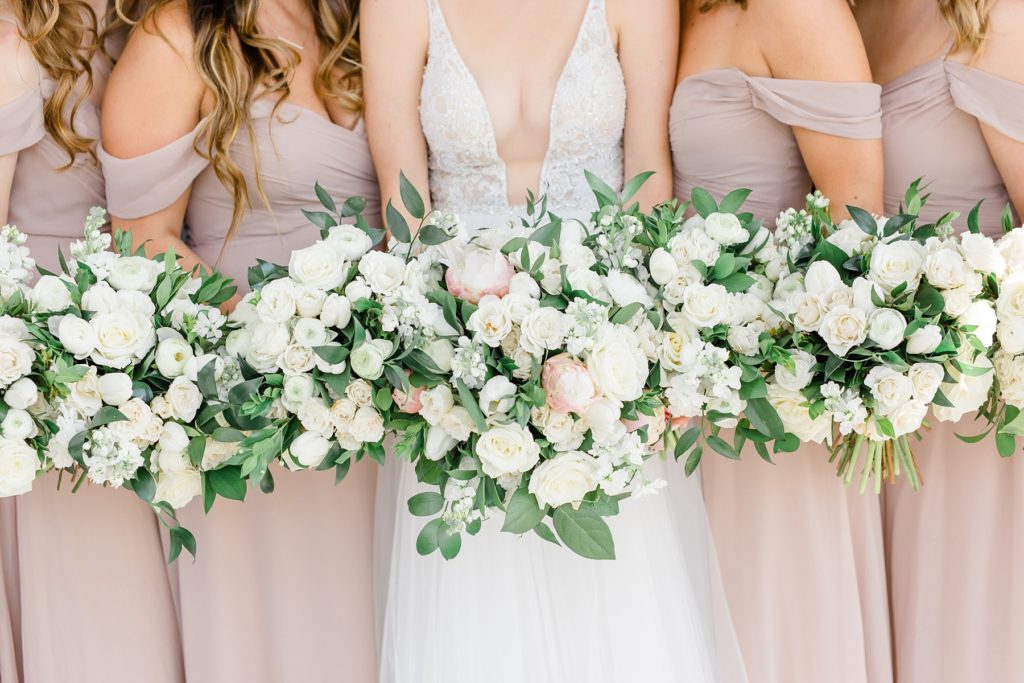 bride and bridesmaids with ivory bouquets pose for Courtney Bosworth Photography