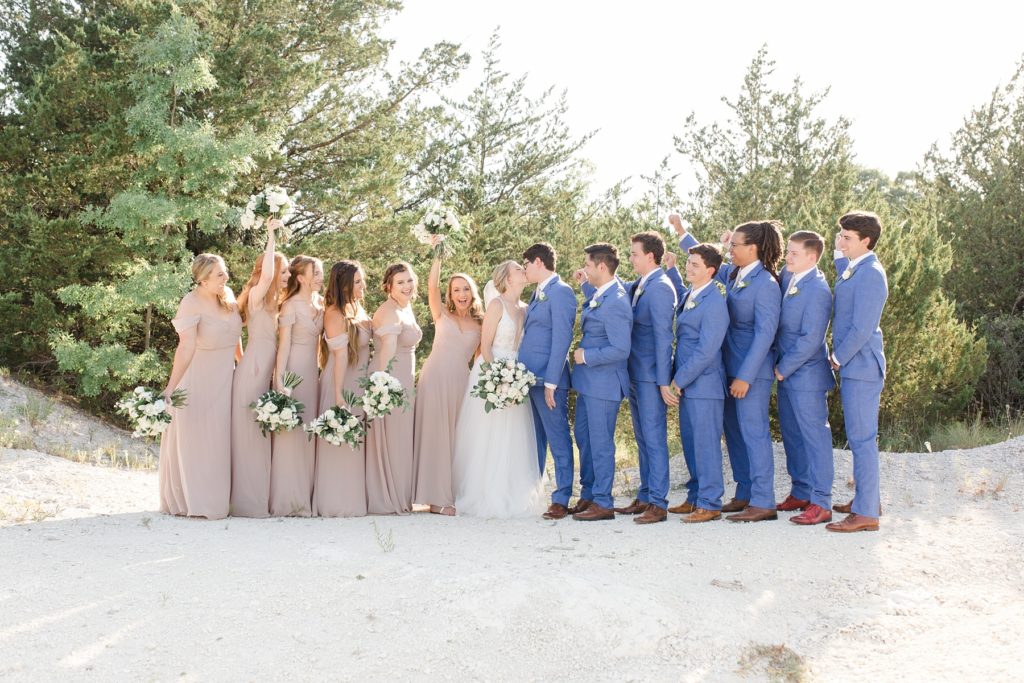 bridal party in blush and blue stands with bride and groom in Texas