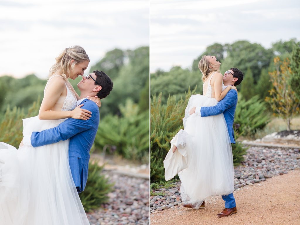groom in navy suit lifts bride up during Stone Crest Venue wedding portraits