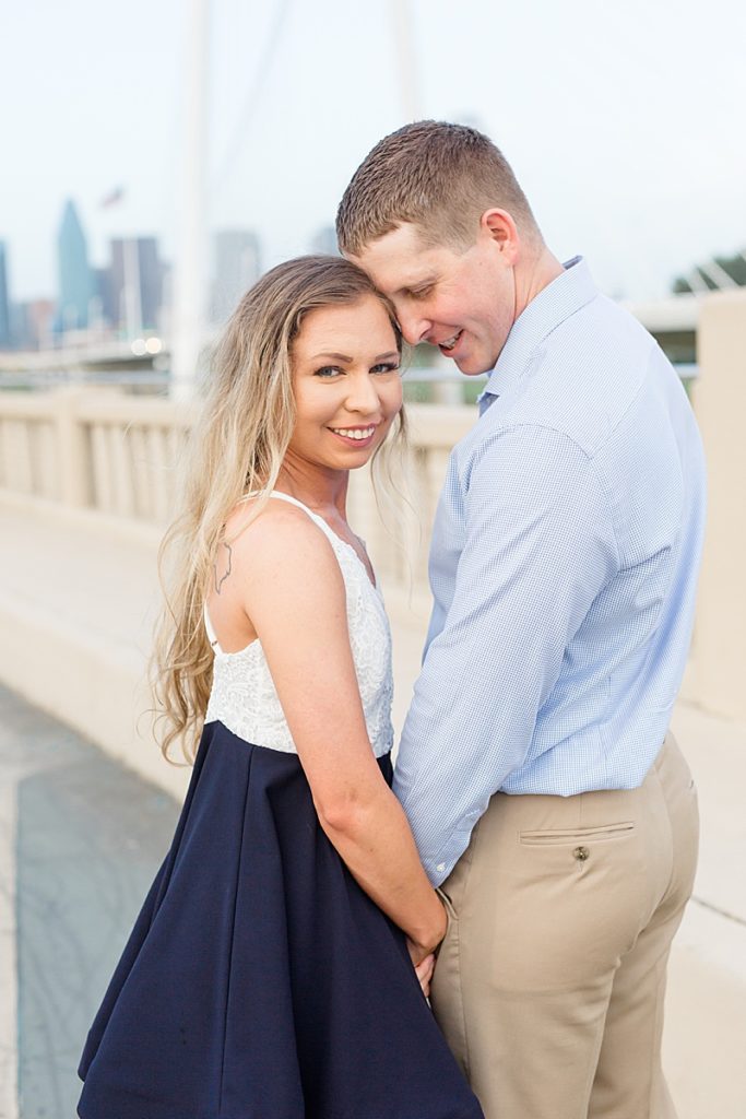 engagement portraits with Dallas skyline behind them