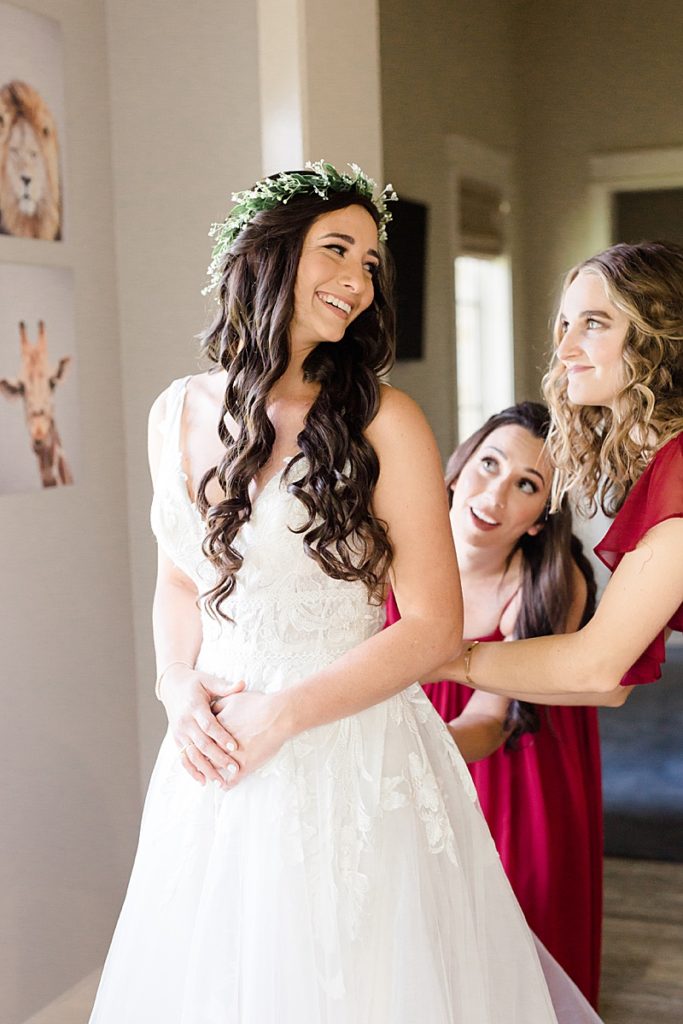 bridesmaids zip up bride on wedding day in Texas