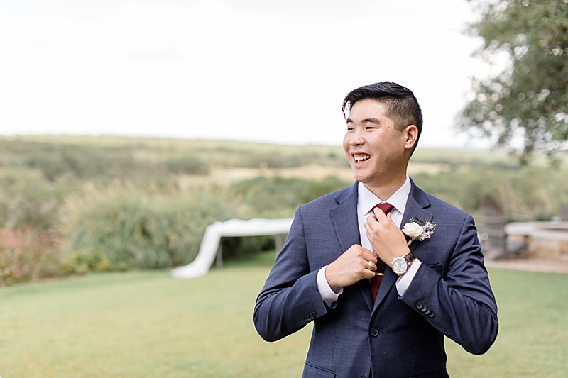 groom adjusts tie before Austin Texas wedding day