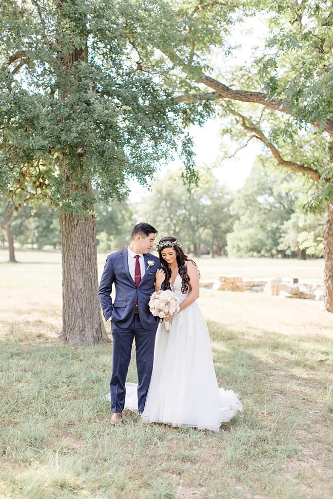 bride and groom walk through grove of trees in Austin TX