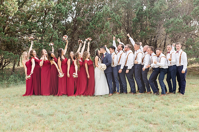 bridal party cheers while newlyweds kiss in Austin TX
