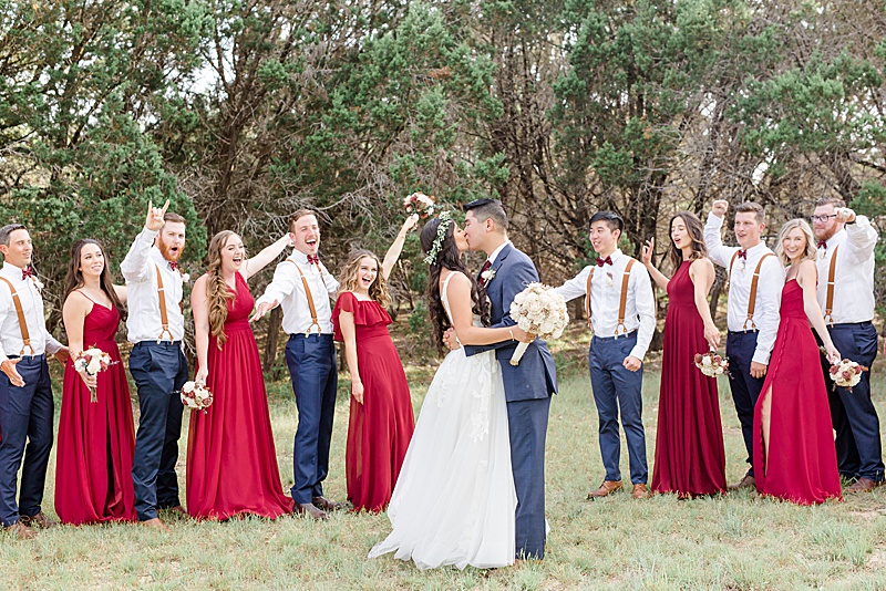 bride and groom kiss during wedding party portraits