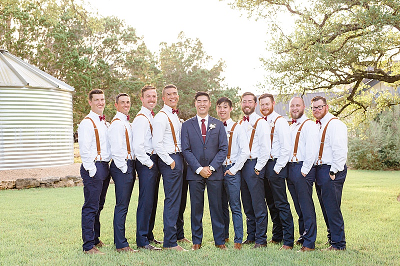 groom poses with 8 groomsmen on Austin TX ranch