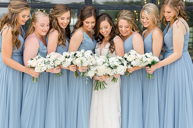 bride and bridesmaids pose with white flowers
