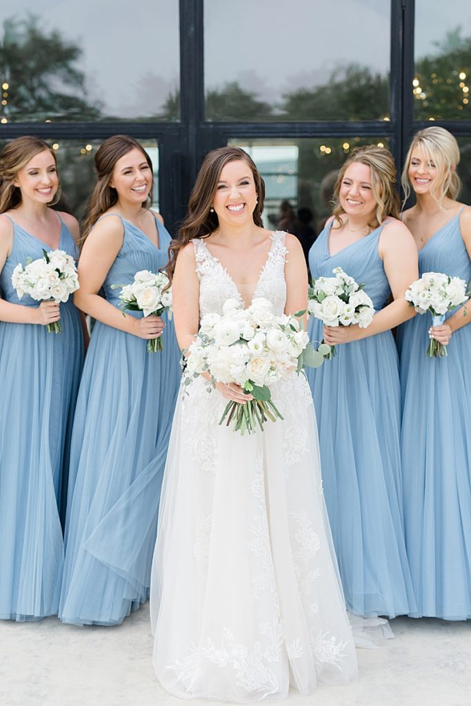 bride with bridesmaids in pastel blue gowns for Mae's Ridge wedding