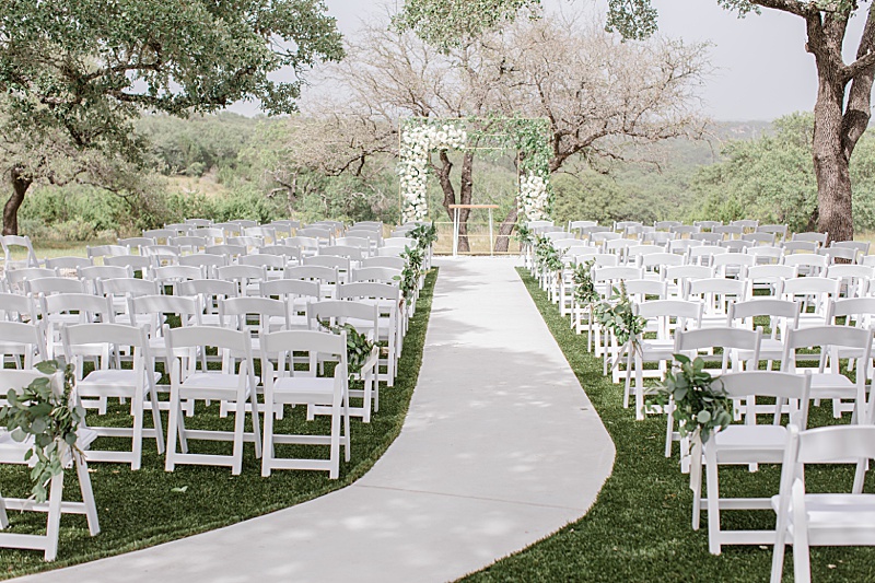 outdoor Mae's Ridge wedding ceremony with arbor with white flowers