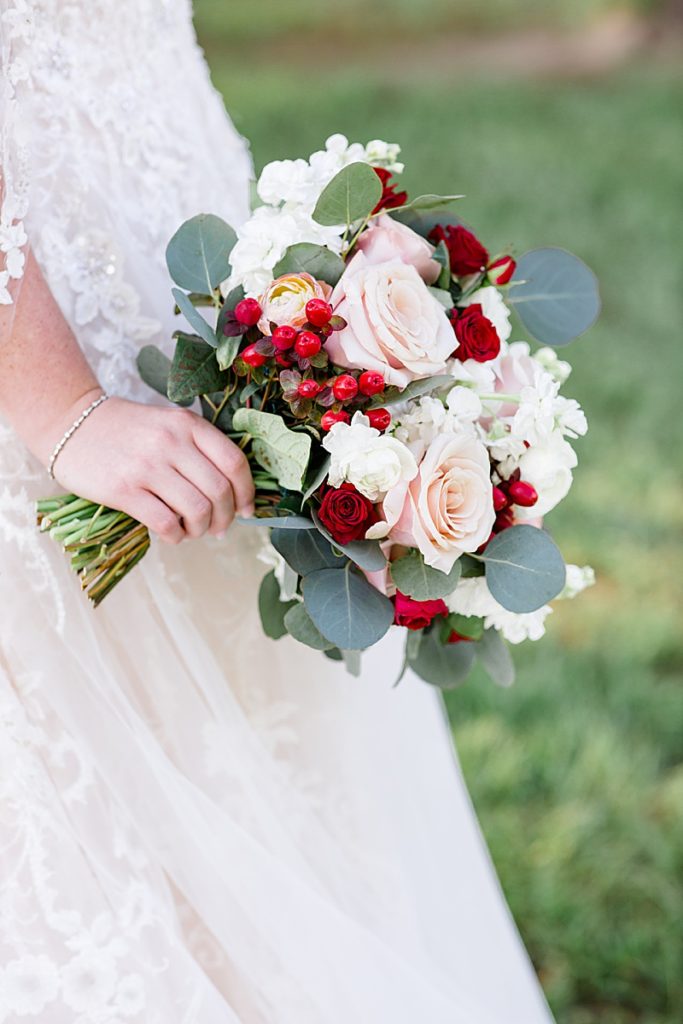 bride holds bouquet with red berries at Texas session