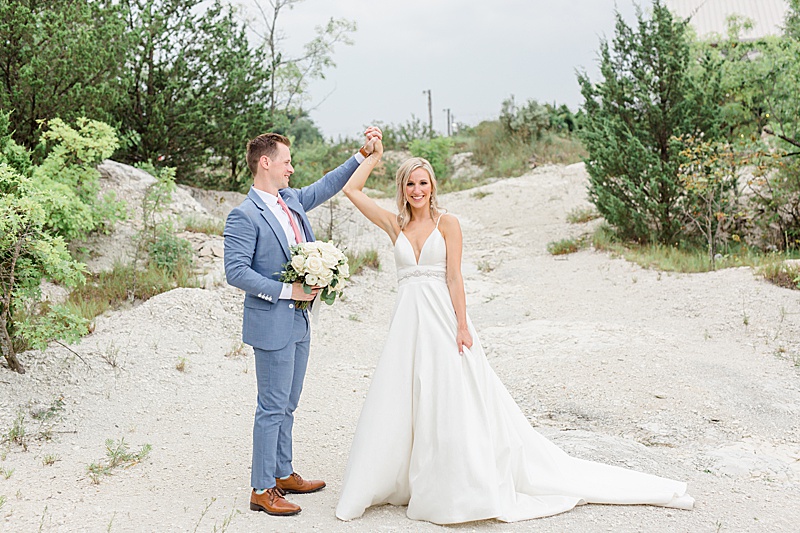 groom twirls bride during wedding portraits in Texas