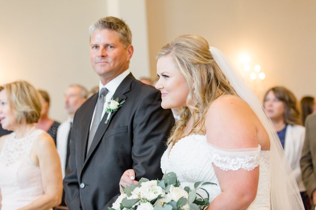 bride walks up aisle to groom with dad