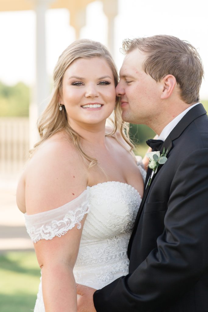 groom nuzzles bride's cheek during wedding portraits in Krum TX