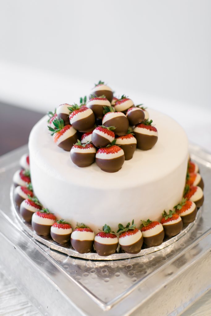 cake with chocolate dipped strawberries on top