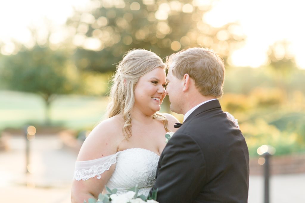 bride and groom smile at each other during sunset