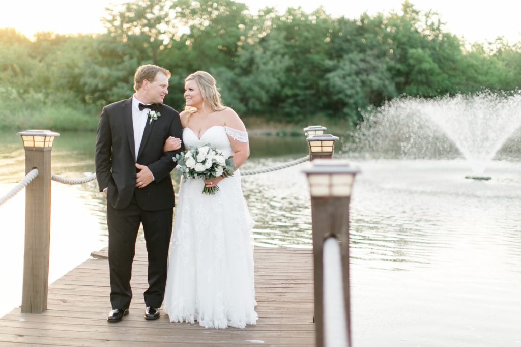 bride and groom walk along dock