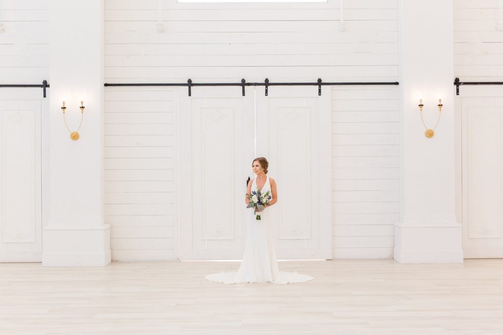 bride holds wedding bouquet by barn doors 