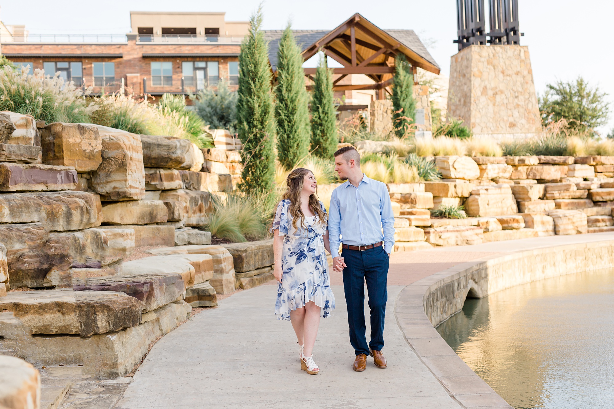 young couple walks through Dallas Arboretum during their engagement session