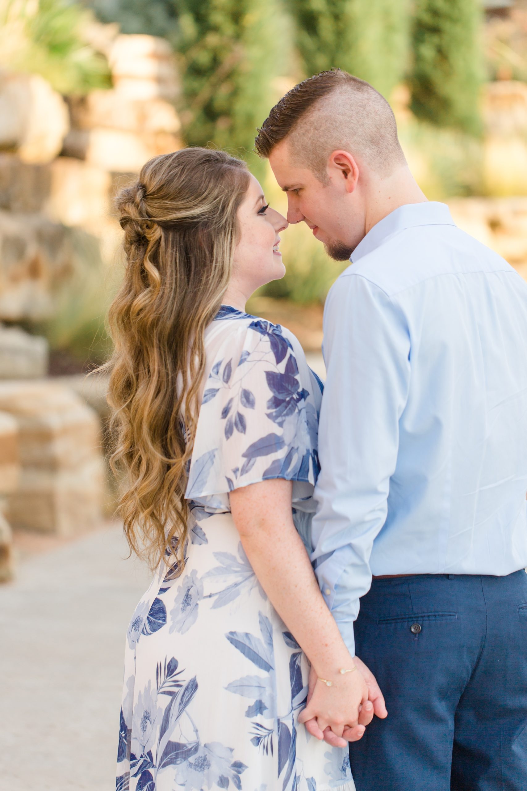 bride and groom stand nose to nose during Dallas Arboretum engagement photos