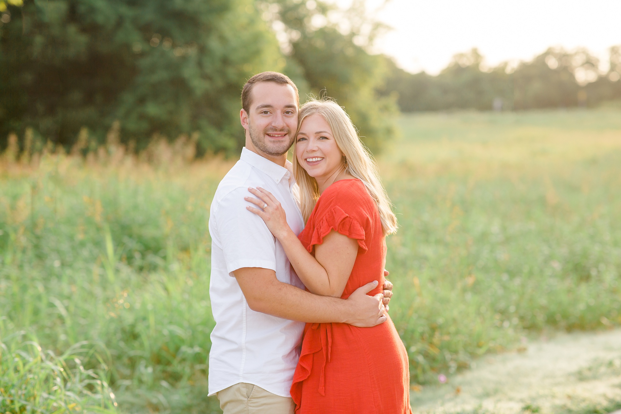 bride and groom hug in field during Texas engagement session