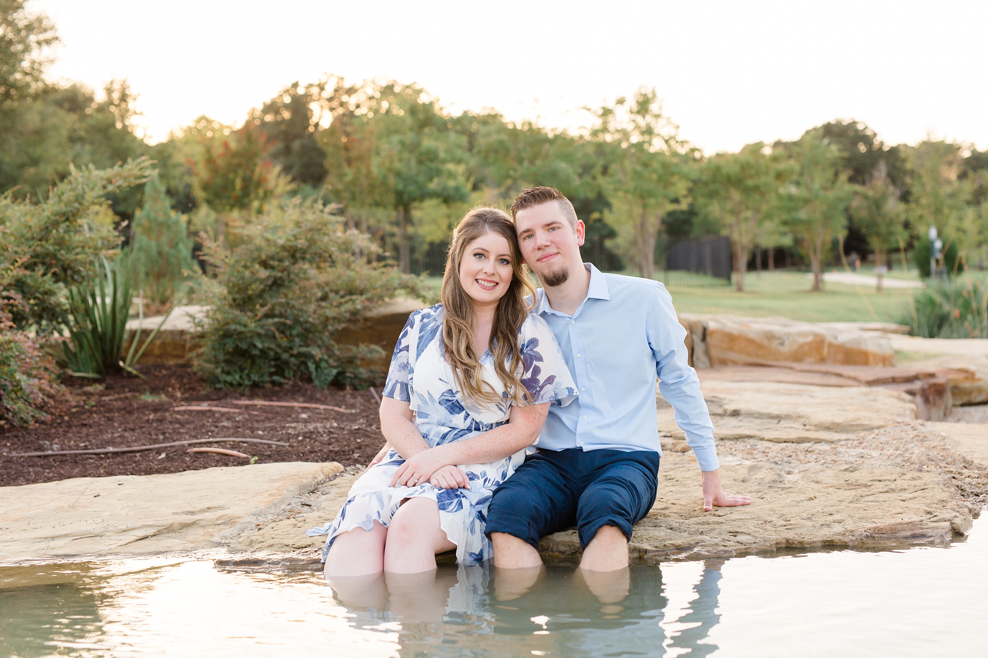 couple dips feet in pool at Dallas Arboretum