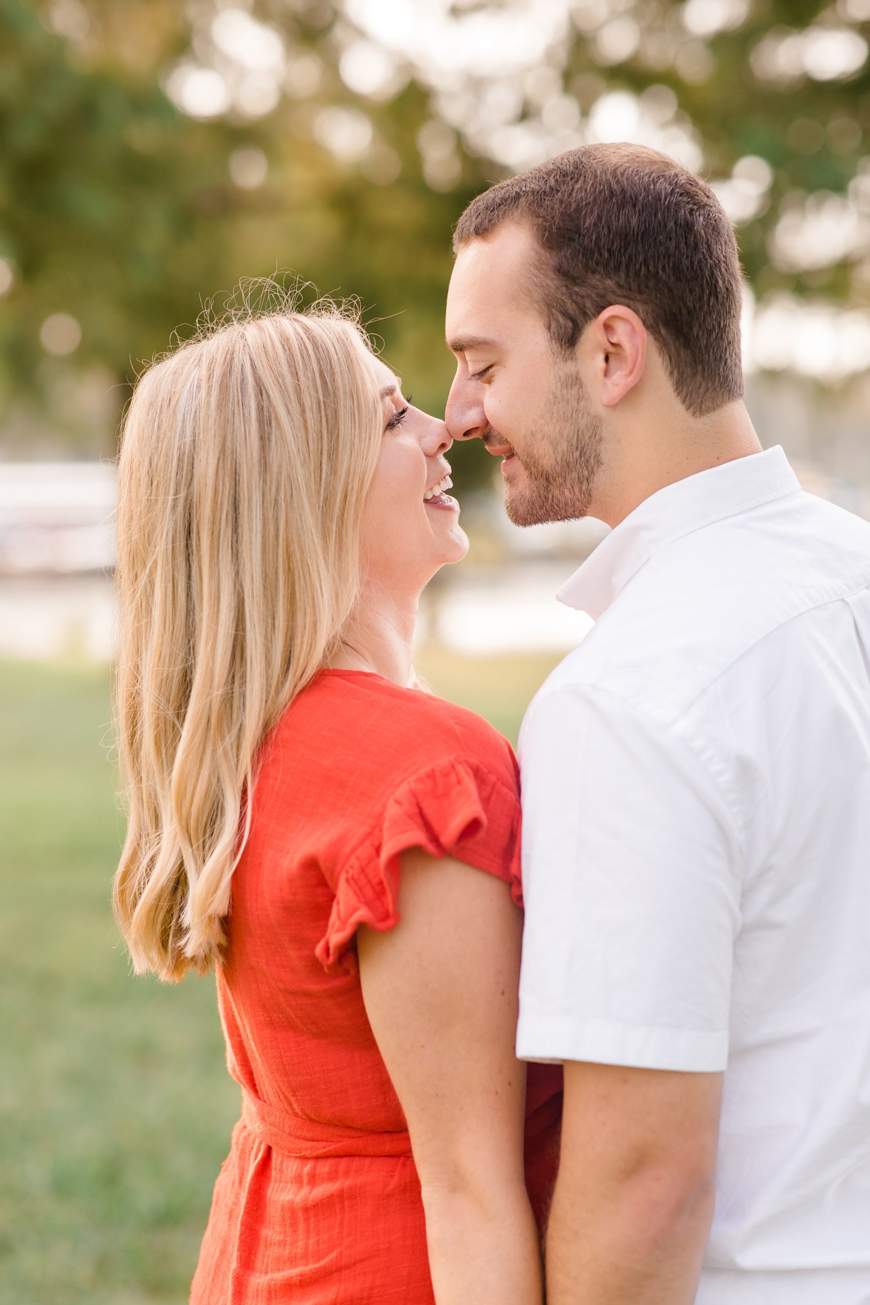 bride and groom stand nose to nose during engagement photos