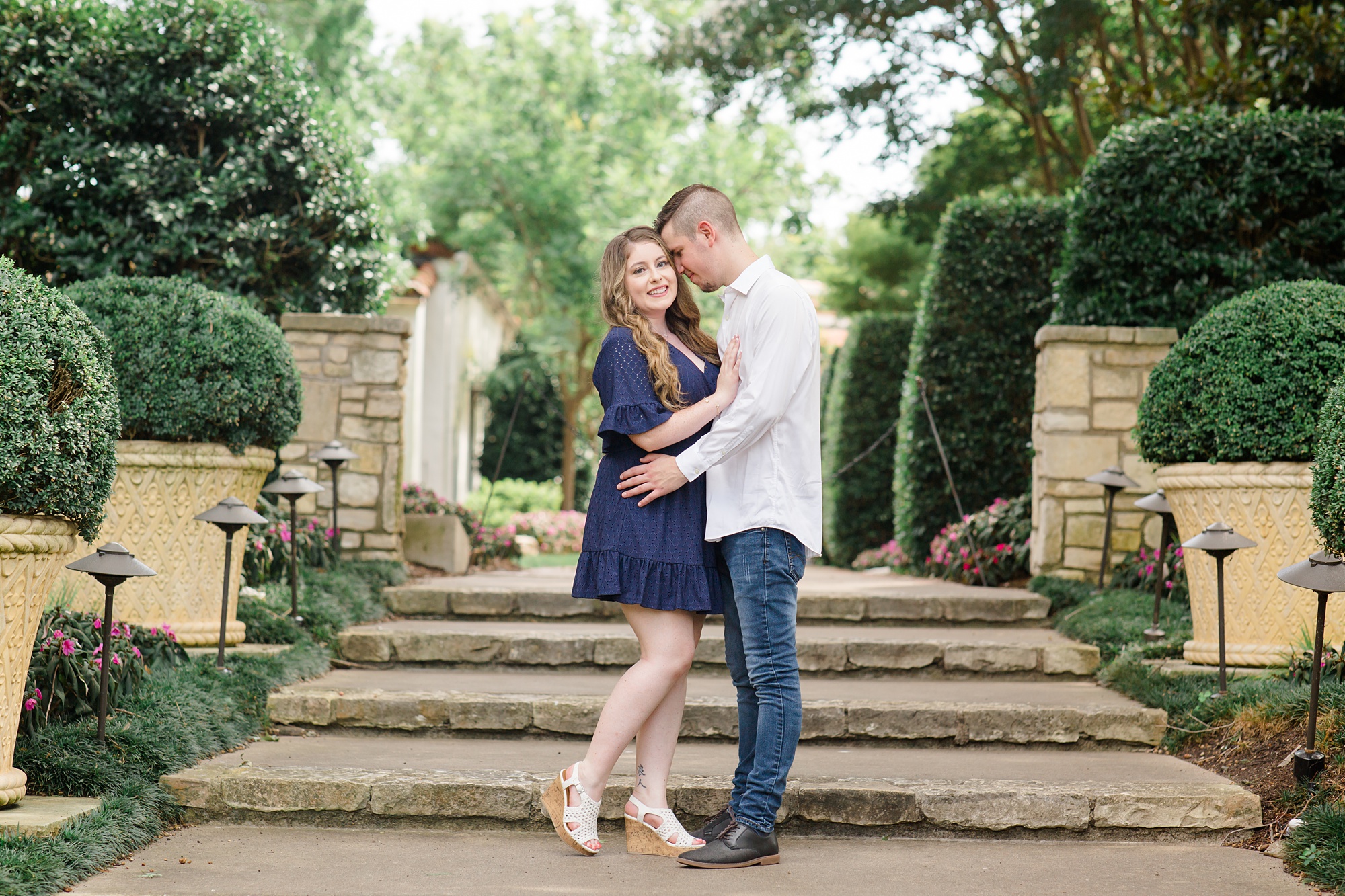 engaged couple walks up steps at Dallas Arboretum