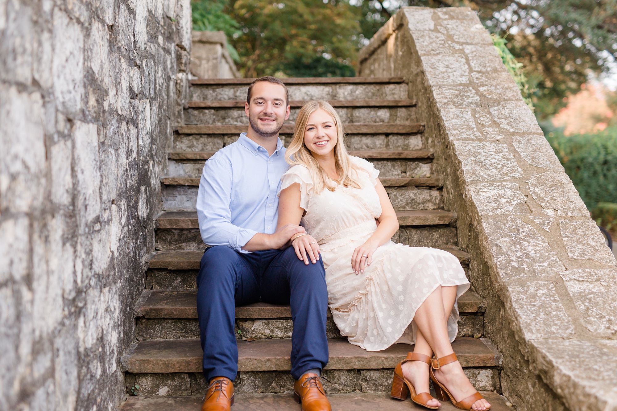 engaged couple sits on steps 