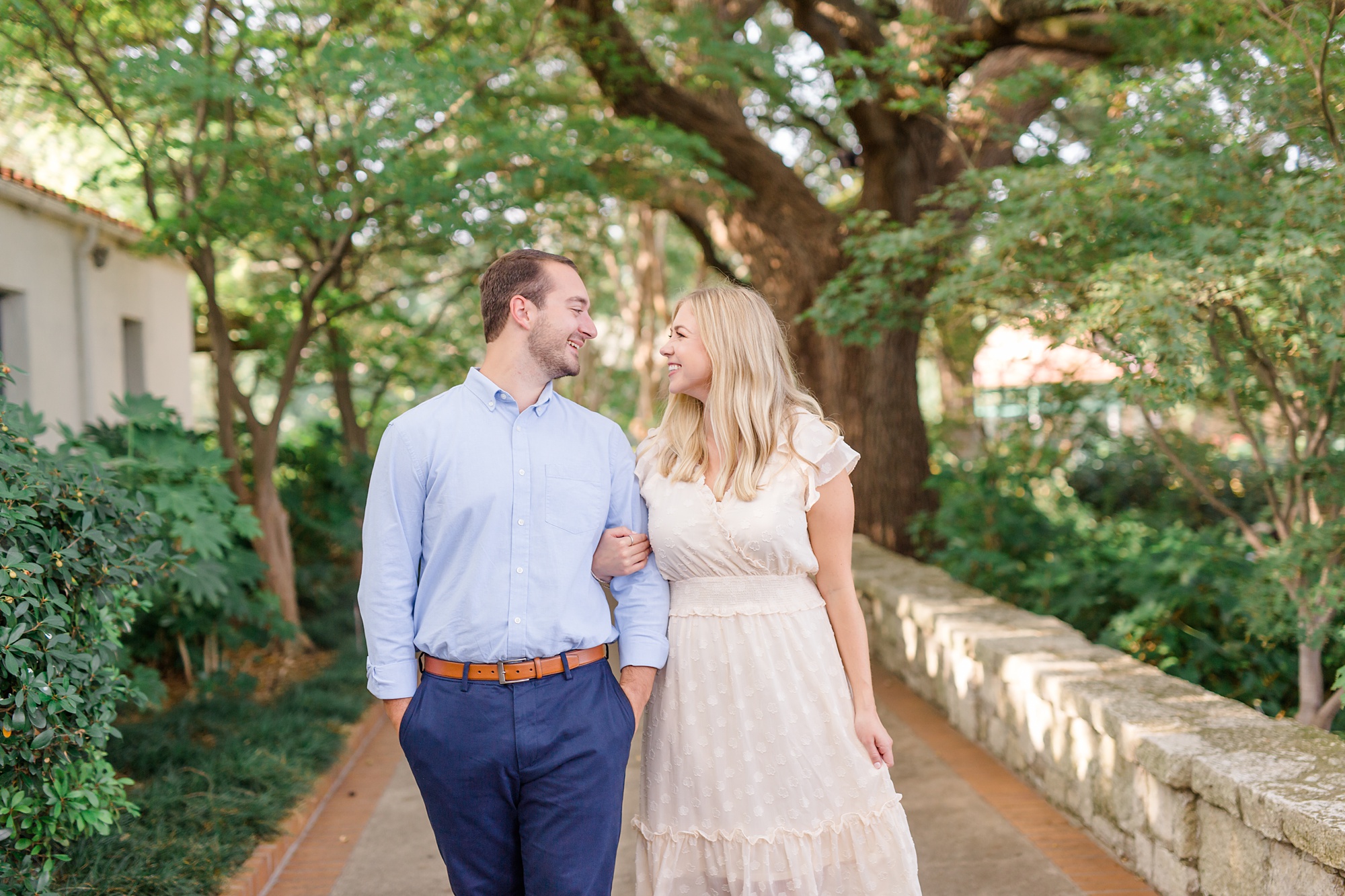 bride and groom hold hands walking through Dallas Arboretum
