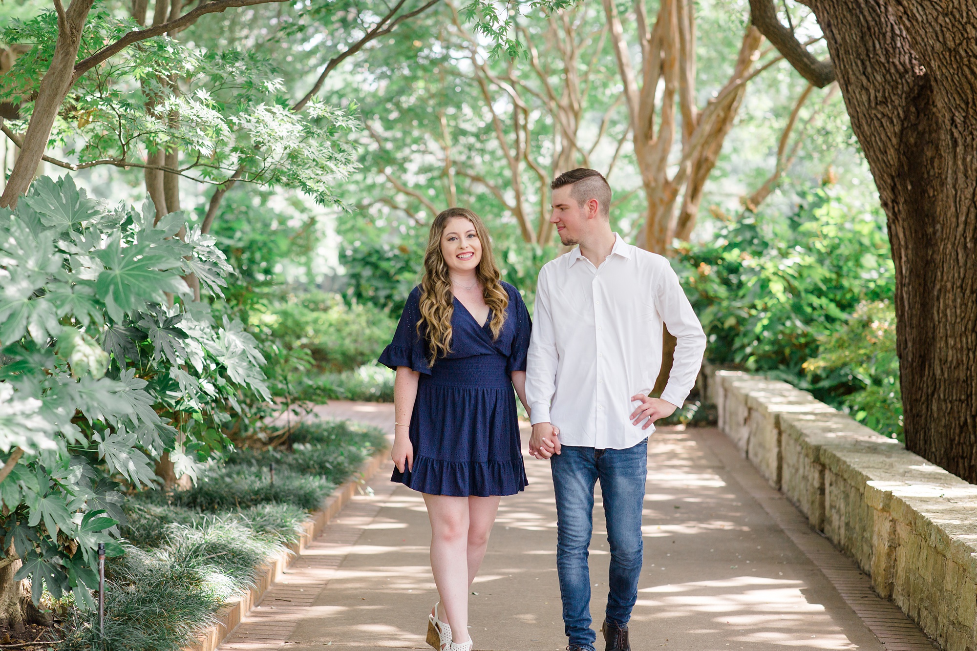 bride and groom walk through Dallas Arboretum
