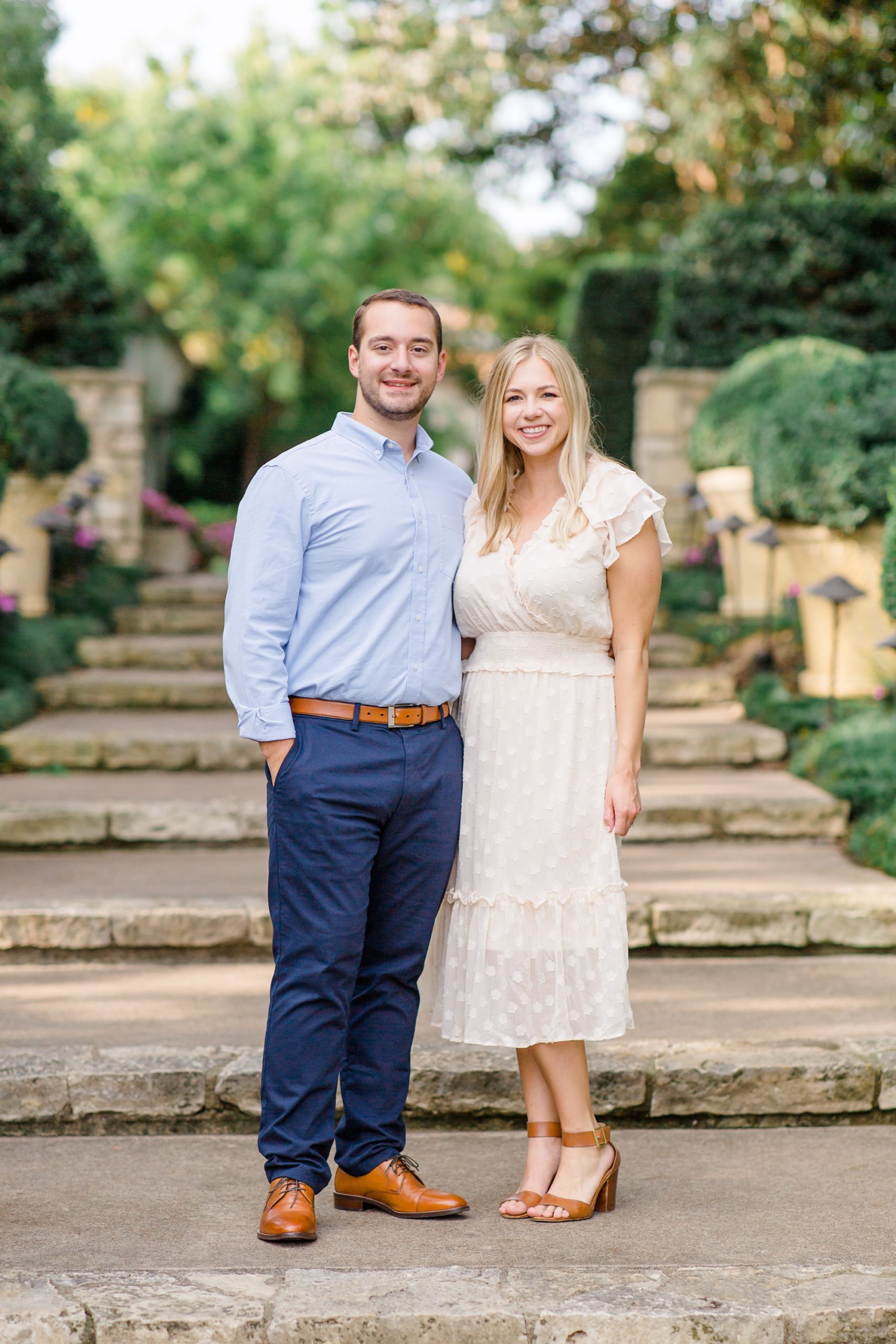 bride and groom stand on steps at Dallas Arboretum
