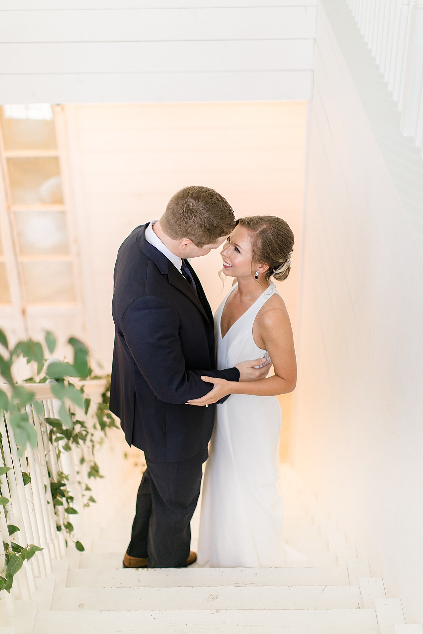 bride and groom kiss on staircase in The Nest at Ruth Farms