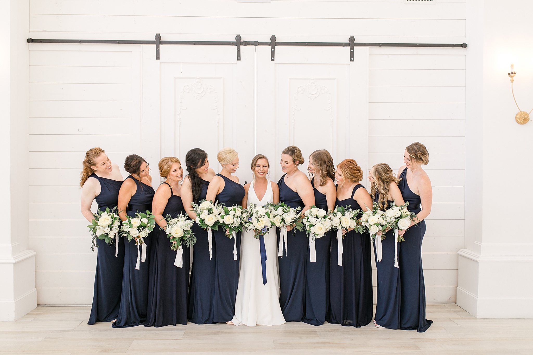 bride poses with bridesmaids outside The Nest at Ruth Farms