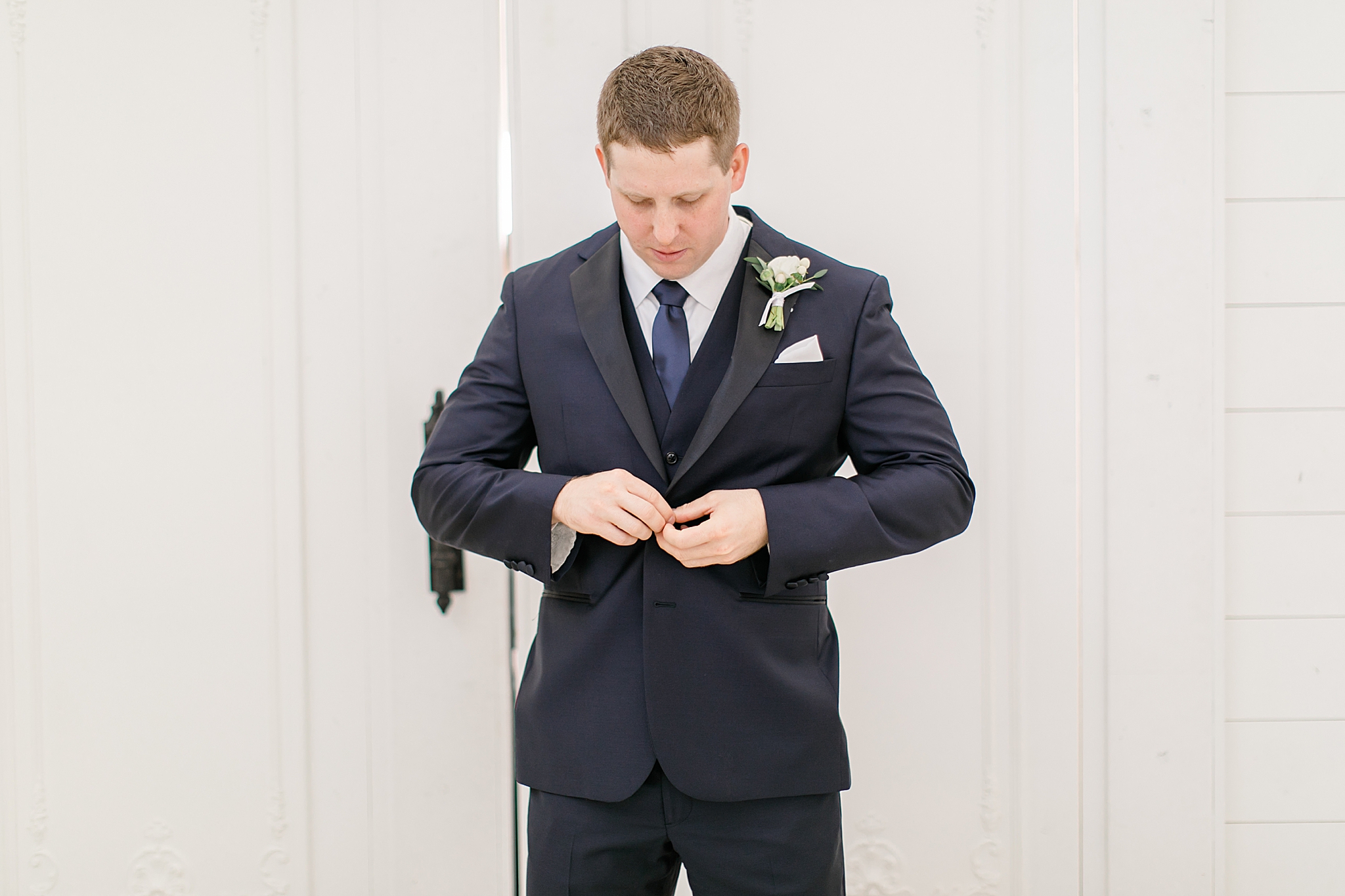 groom adjusts suit jacket before Dallas Tx wedding 