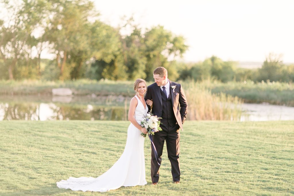 newlyweds pose by pond in Dallas TX