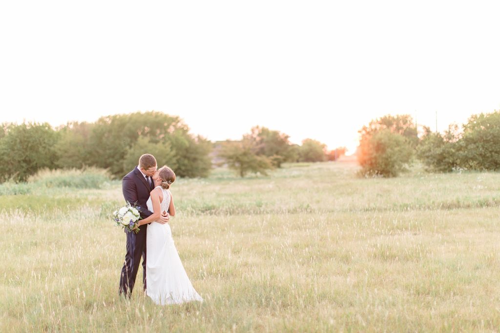 newlyweds kiss in field at The Nest at Ruth Farms