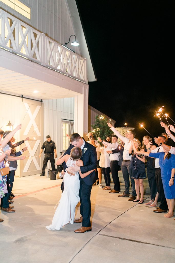 newlyweds kiss outside The Nest at Ruth Farms during sparkler exit