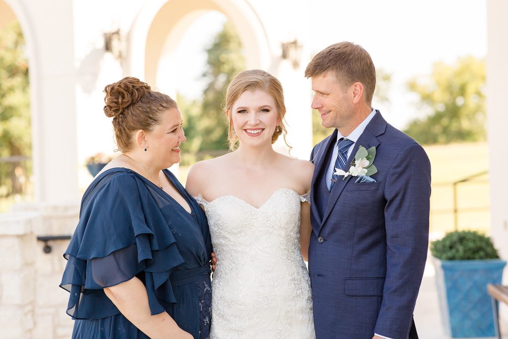 bride poses with mom and dad