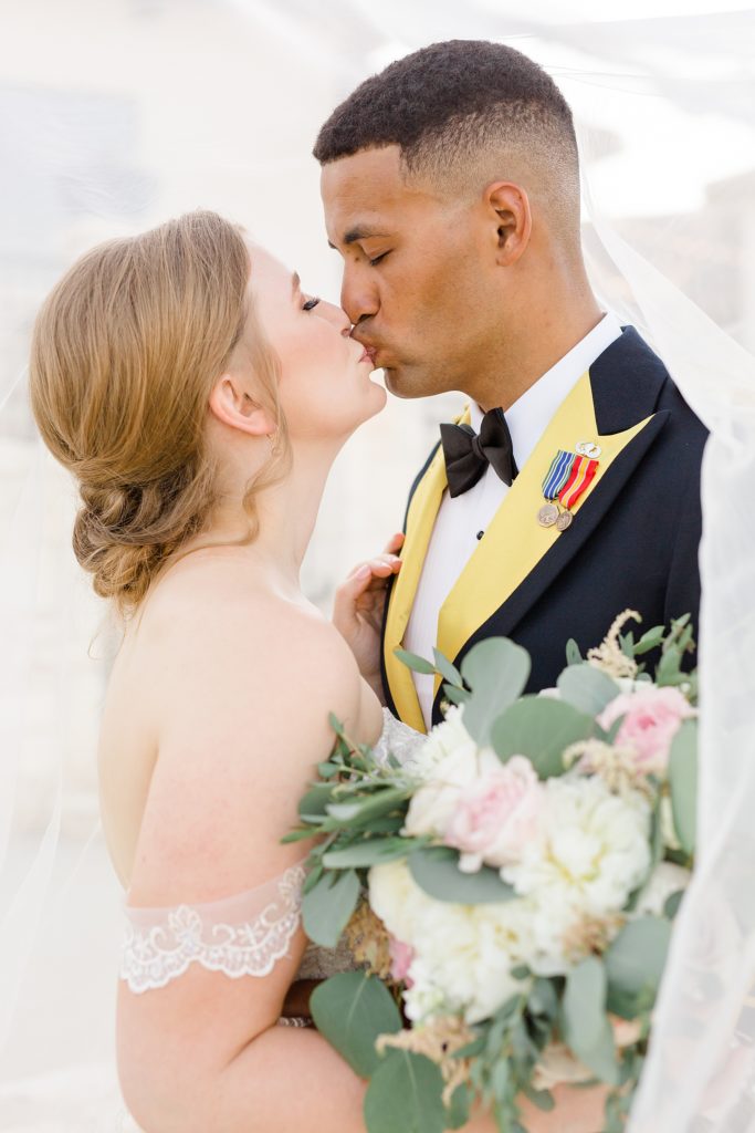 bride and groom kiss during vineyard wedding