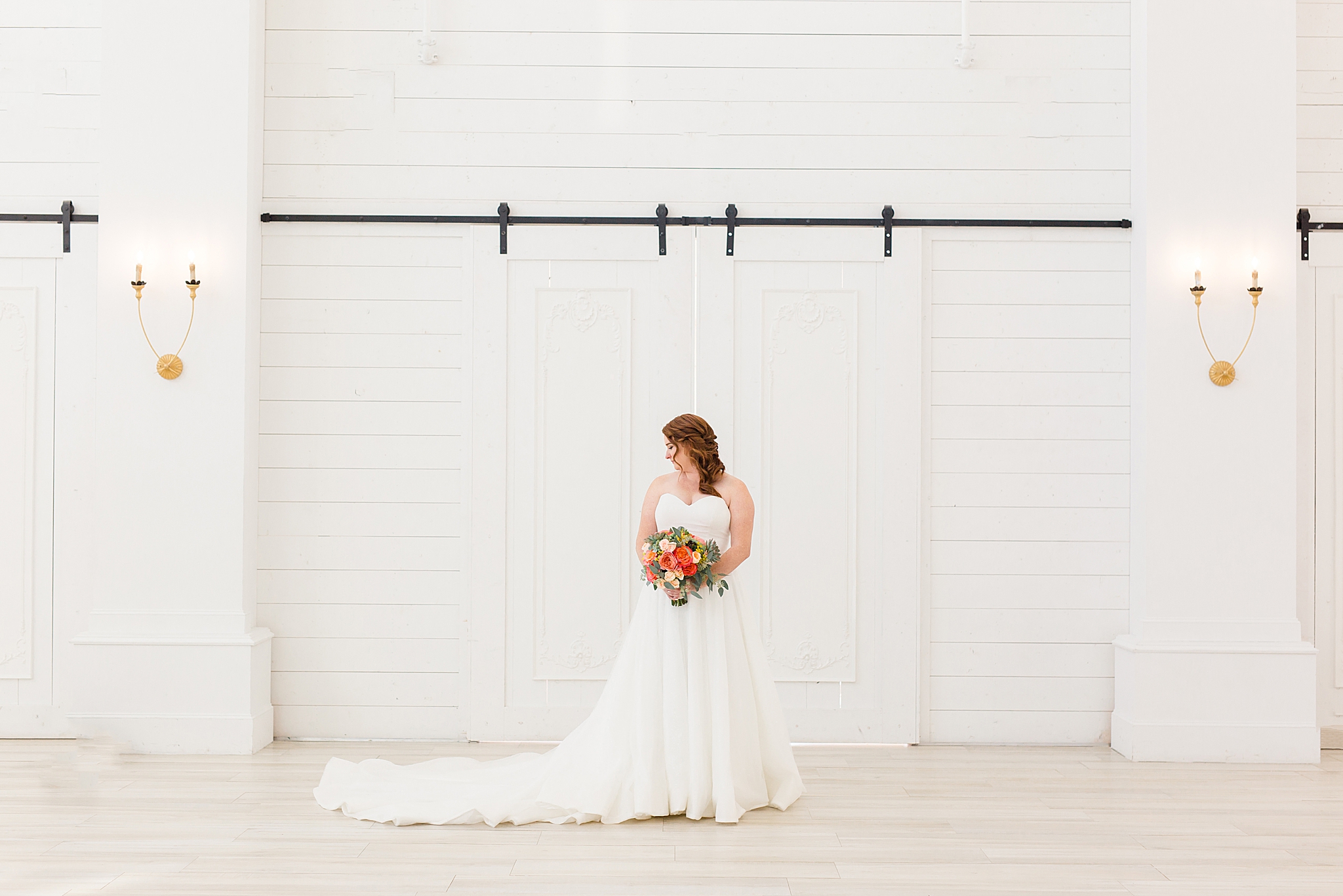 bride stands near barn doors at The Nest at Ruth Farms