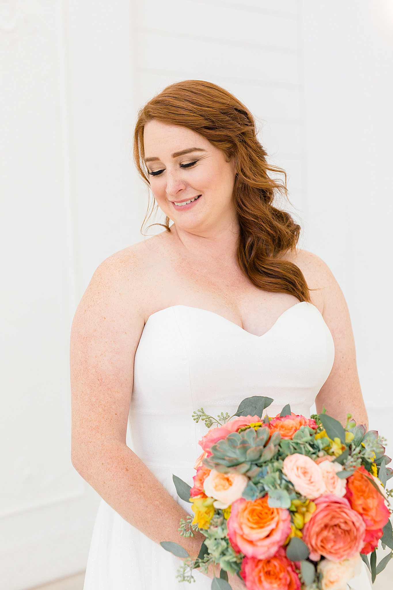 bride looks over shoulder while holding bouquet