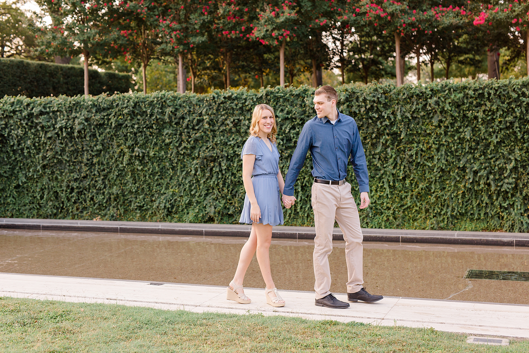 couple walks in front of ivy wall at Kimball Art Museum
