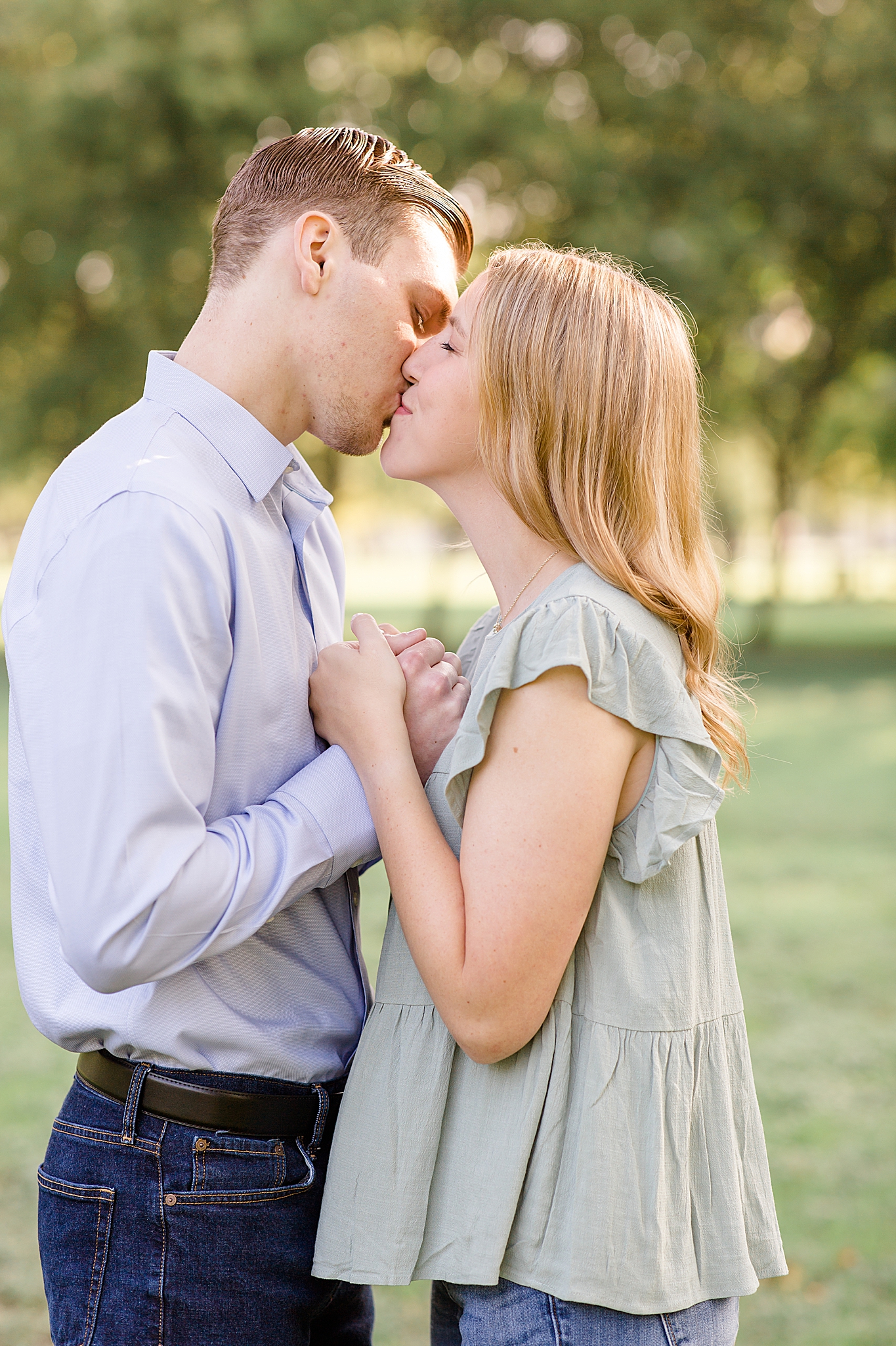 engaged couple kisses during sunrise engagement session at Kimball Art Museum